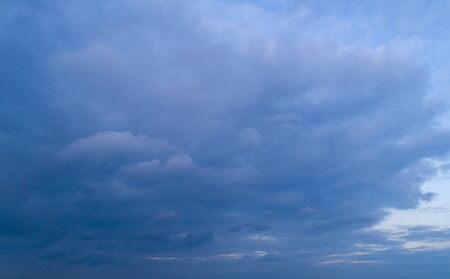 Dark cloudy sky with red reflections at sunsetの写真素材