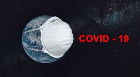 Planets Earth with a medical mask with the inscription Covid 19 against the starry sky. Conceptの写真素材
