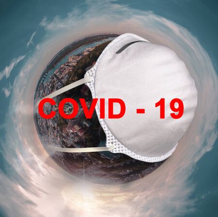Globe with a protective mask with the inscription Covid 19.の写真素材