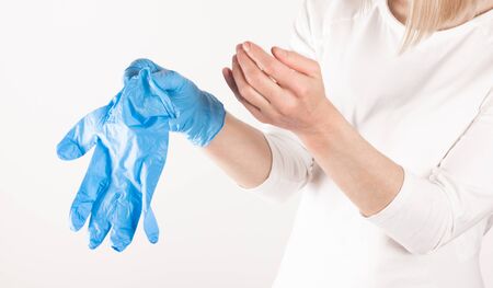 Woman puts on medical gloves close up.の写真素材