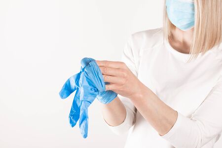 Woman puts on medical gloves close up.の写真素材