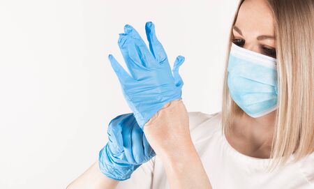 Woman puts on medical gloves close up.の写真素材