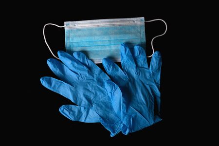 Blue medical sterile mask and blue sterile gloves isolated on a blackの写真素材