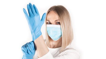 Woman puts on medical gloves close up.の写真素材