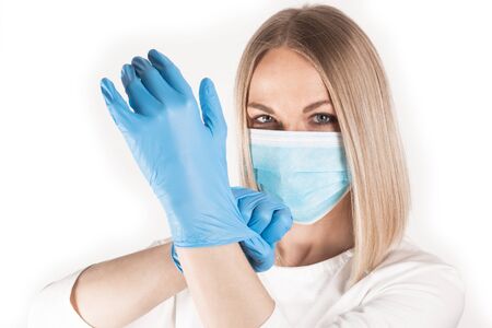 Woman puts on medical gloves close up.の写真素材