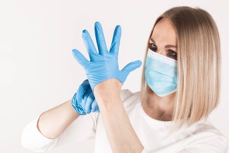 Woman puts on medical gloves close up.の写真素材