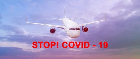 Large sky panorama with flying airplane and the inscription Stop Covid 19.の写真素材