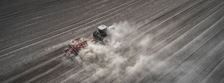 Farmers cultivating. Tractor makes vertical tillage.の写真素材