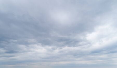 Cloudy gray and white sky with thick dense clouds.の写真素材