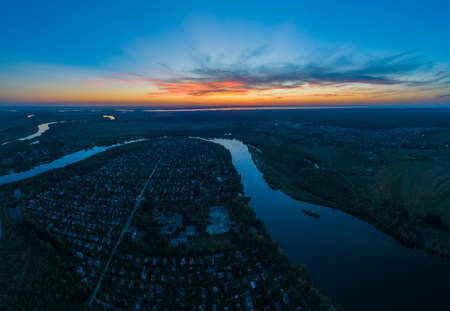 Panoramic aerial view of the nature landscape with green meadows and a river at sunset.の写真素材
