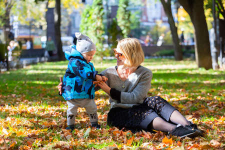 Little boy with mother in park in autumnの写真素材