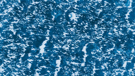 Blue ice surface with scratches and snow