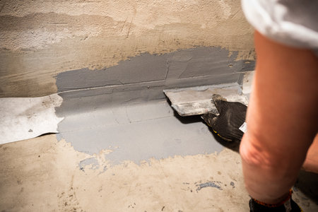 Applying a waterproofing tape to the joint between the wall and the floor. Internal construction worksの写真素材