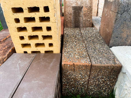 Different types of bricks stacked beautifully on green grassの写真素材