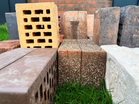 Different types of bricks stacked beautifully on green grassの写真素材