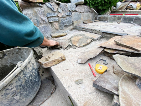 A man lays a stone on the paths on the mortarの写真素材