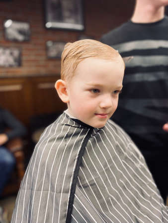 Master cuts a little boys hair in a barbershopの写真素材