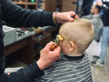 Master cuts a little boys hair in a barbershopの写真素材