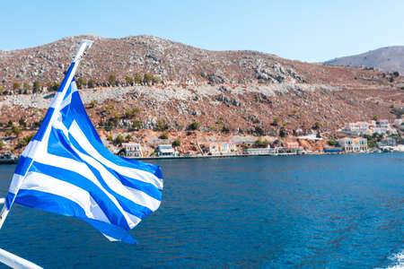 Flag of Greece on a cruise ship against greek coastlineの写真素材