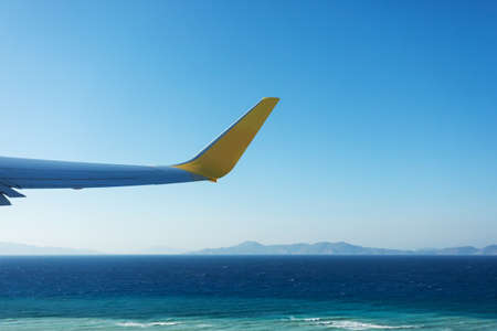 View from the airplane window to the sea during takeoff.の写真素材