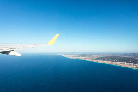 View from the airplane window to the sea during takeoff.の写真素材