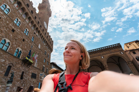 Woman making a photo near Palazzo Vecchio, in Florence.の写真素材