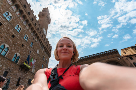 Woman making a photo near Palazzo Vecchio, in Florence.の写真素材