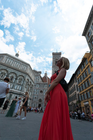 Young woman tourist taking photo on background of Cathedral of Santa Maria del Fiore with Duomo in Florence, Italyの写真素材