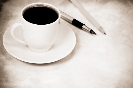 sepia image of cup of coffee and office accessoryの写真素材