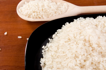 rice and ceramic black plate with spoon on tableの写真素材