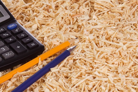 calculator and pencil at wooden shaving