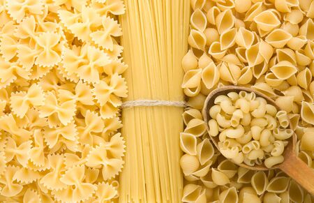 uncooked raw pasta and wood spoonの写真素材