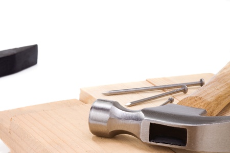 hammer and nail on wood bar on white backgroundの写真素材