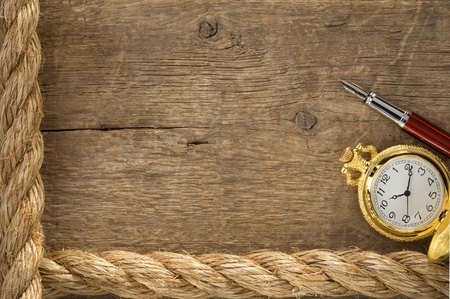 ship ropes and watch with ink pen on old wooden background