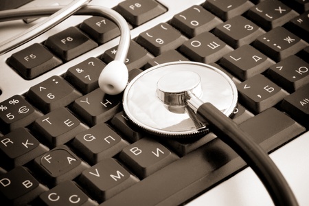 sepia stethoscope at keyboard background