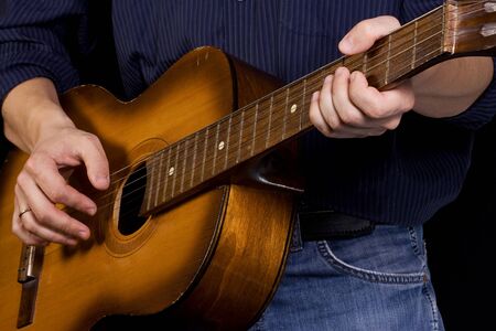 man in jeans playing guitar