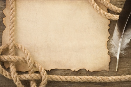 ropes and feather on old vintage ancient paper background textureの写真素材