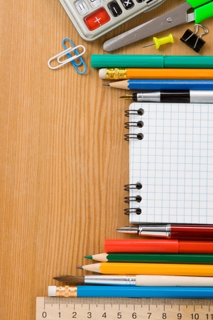 school supplies and checked notebook on wood backgroundの写真素材