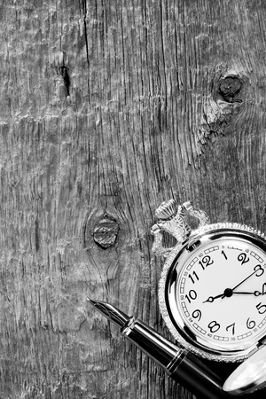 ink pen and watch on wooden backgroundの写真素材