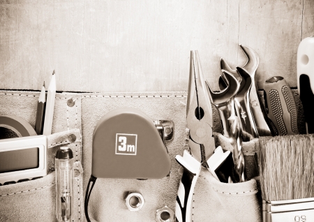 tools in construction belt on wooden background textureの写真素材