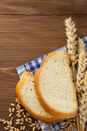 sliced bread and ears of wheat on napkinの写真素材
