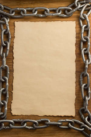 metal chain and old vintage ancient paper at wooden background