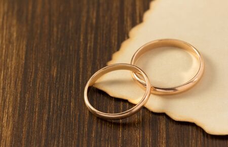 wedding ring and aged paper on wooden backgroundの写真素材