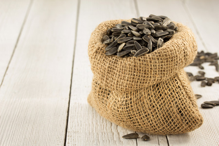 sunflower seeds in bag on wooden backgroundの写真素材