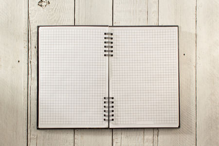checked notebook on wood background