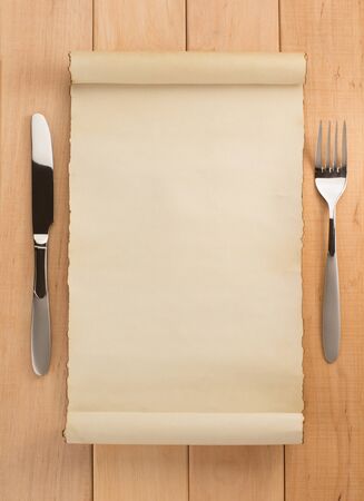 parchment and fork with knife on wooden backgroundの写真素材