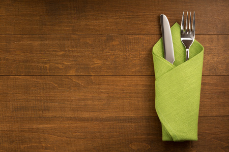 knife and fork at napkin on wooden backgroundの写真素材