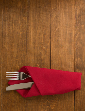 knife and fork at napkin on wooden backgroundの写真素材