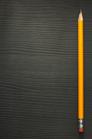 yellow pencil on wooden textureの写真素材