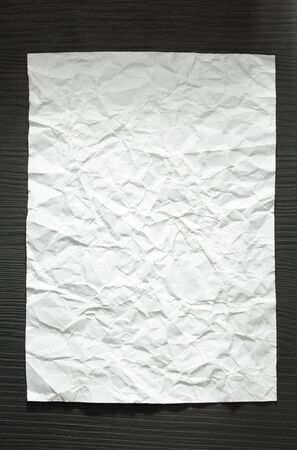 wrinkled paper at wooden backgroundの写真素材
